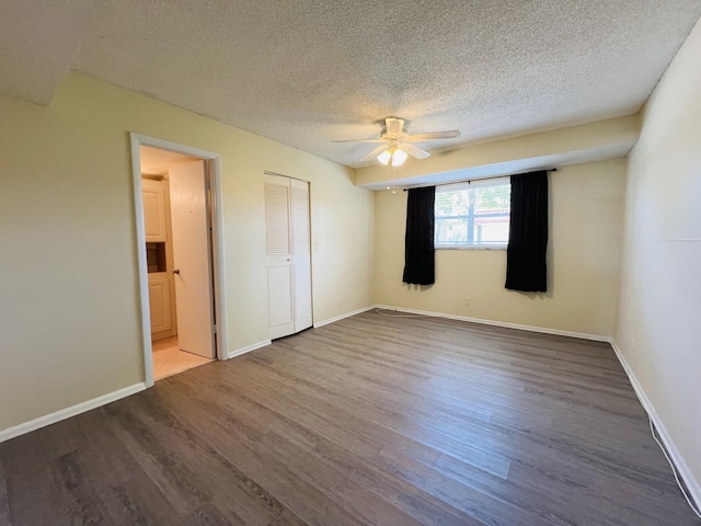 unfurnished bedroom featuring a closet, ceiling fan, hardwood / wood-style floors, and a textured ceiling