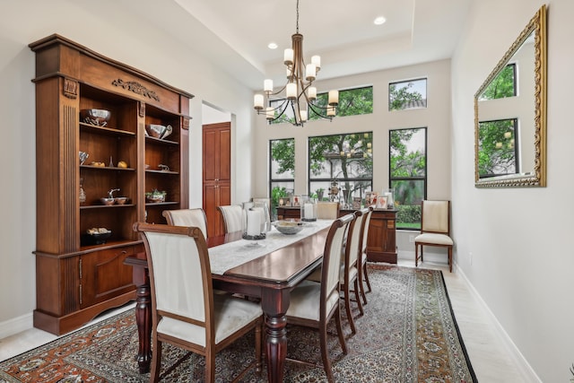 dining area featuring an inviting chandelier, hardwood / wood-style flooring, and a tray ceiling