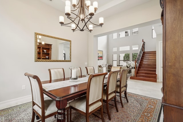 dining room with a high ceiling, a chandelier, and tile patterned floors