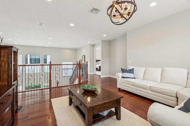 living room featuring dark wood-type flooring and a notable chandelier