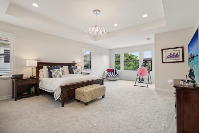 carpeted bedroom with a raised ceiling and an inviting chandelier