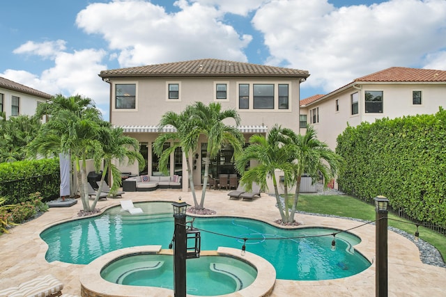 rear view of house featuring a patio area and a swimming pool with hot tub