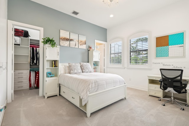 bedroom with a spacious closet, light carpet, and a closet