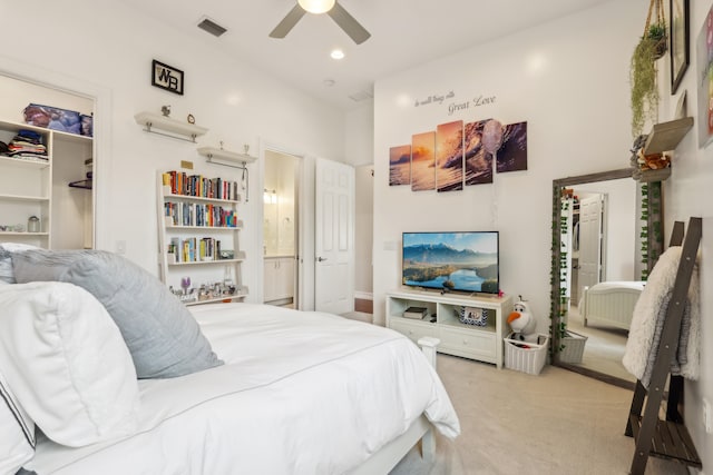 carpeted bedroom with connected bathroom and ceiling fan