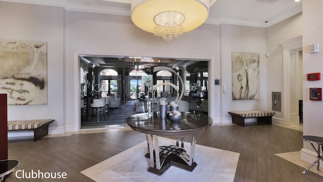 interior space with french doors, wood-type flooring, ornamental molding, and a notable chandelier