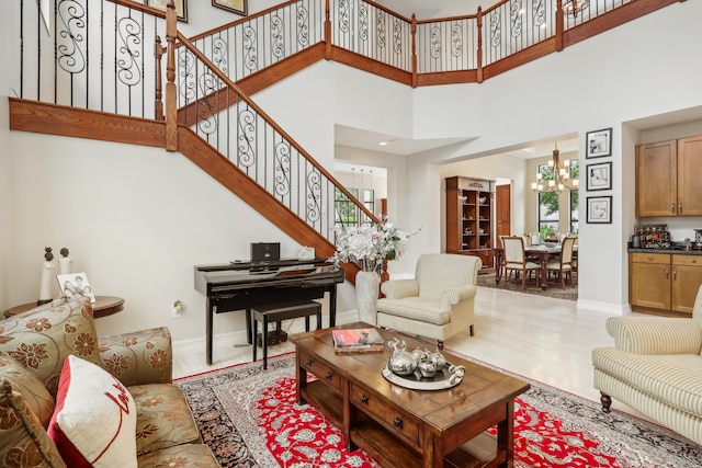 tiled living room featuring a towering ceiling and a chandelier