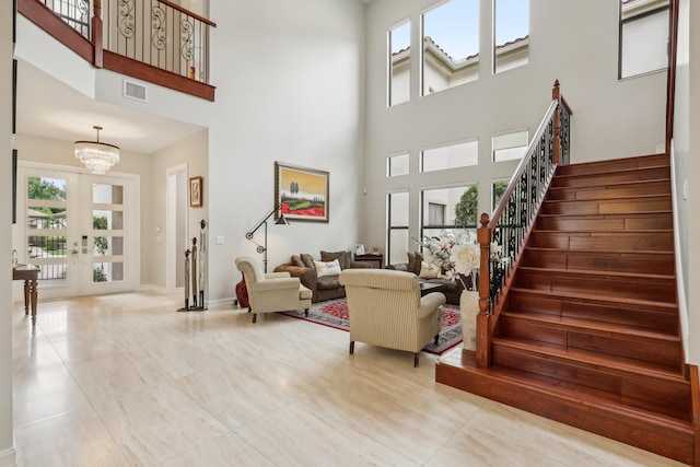 living room with a notable chandelier, a high ceiling, french doors, and tile patterned flooring