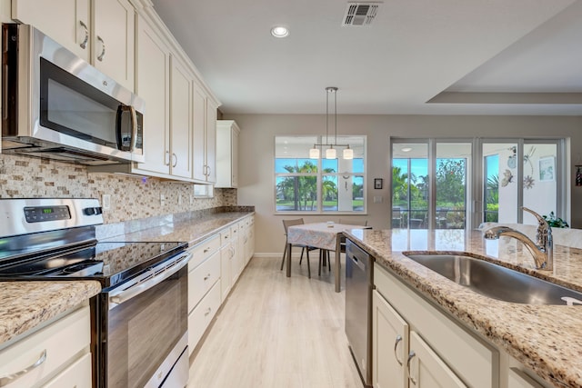 kitchen featuring sink, light hardwood / wood-style flooring, tasteful backsplash, and stainless steel appliances