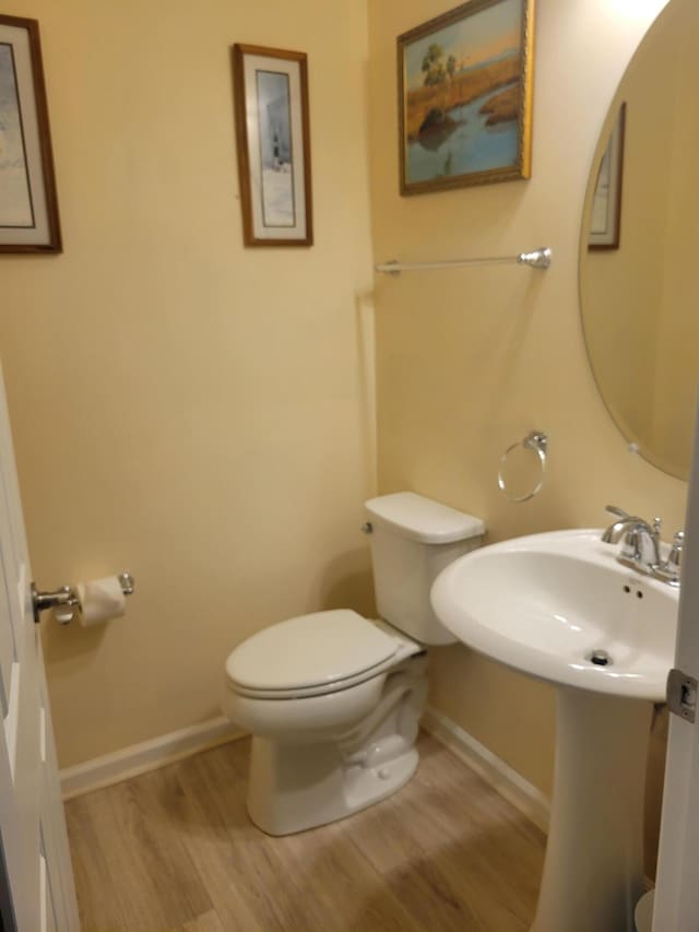 bathroom featuring wood-type flooring and toilet