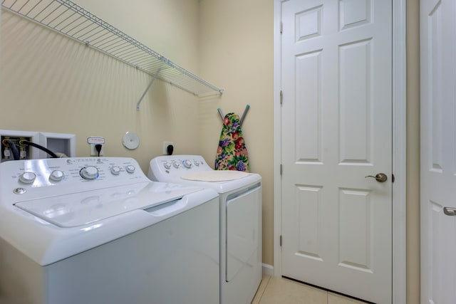 laundry room featuring independent washer and dryer and light tile patterned floors