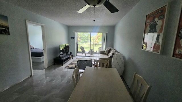 living room featuring a textured ceiling, marble finish floor, and ceiling fan