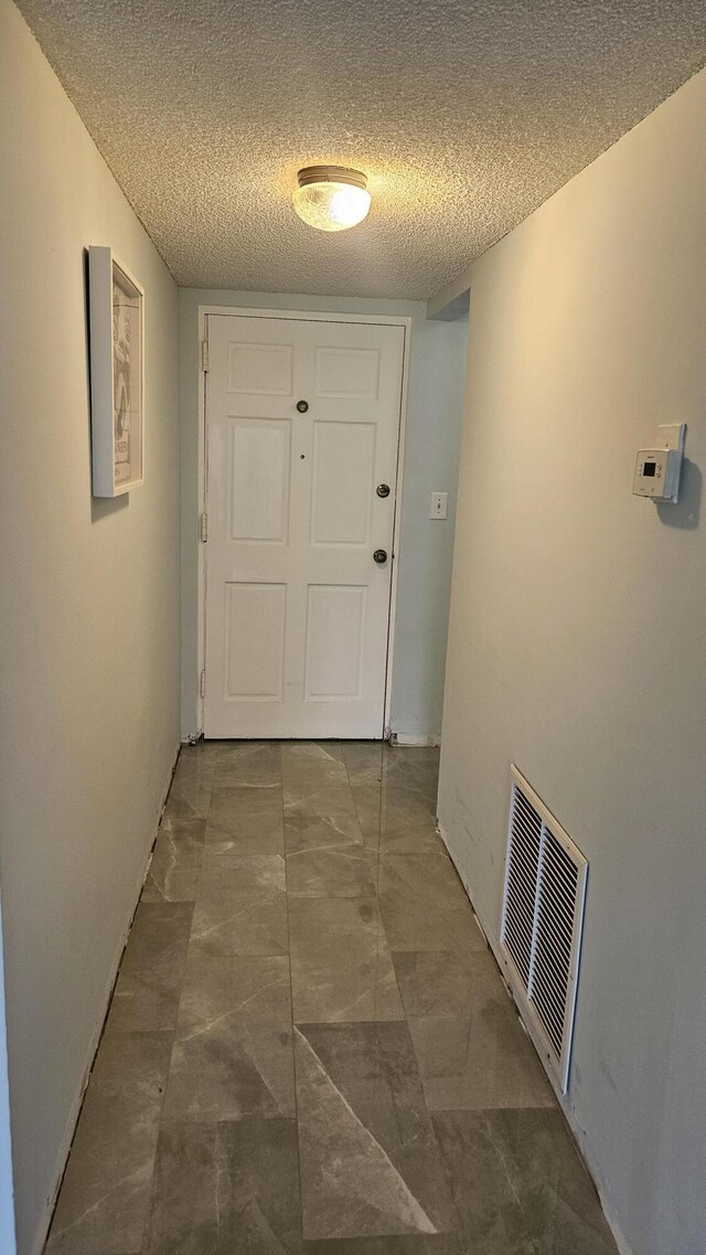corridor with a textured ceiling and visible vents