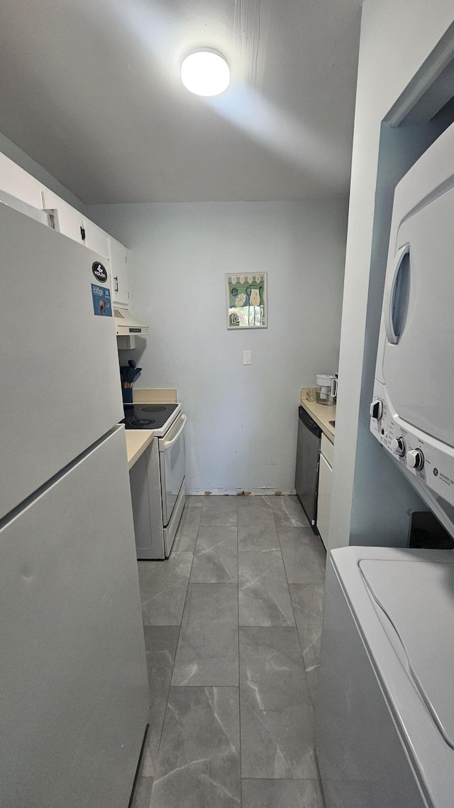 washroom featuring marble finish floor, stacked washing maching and dryer, and laundry area