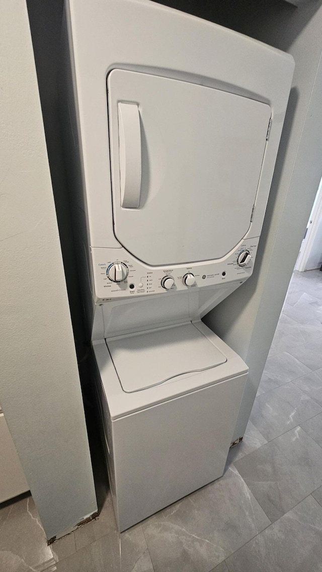 laundry area featuring stacked washer and clothes dryer and laundry area
