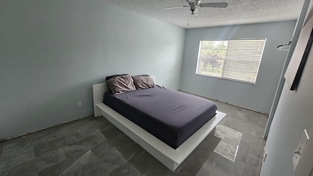 bedroom featuring a ceiling fan and a textured ceiling