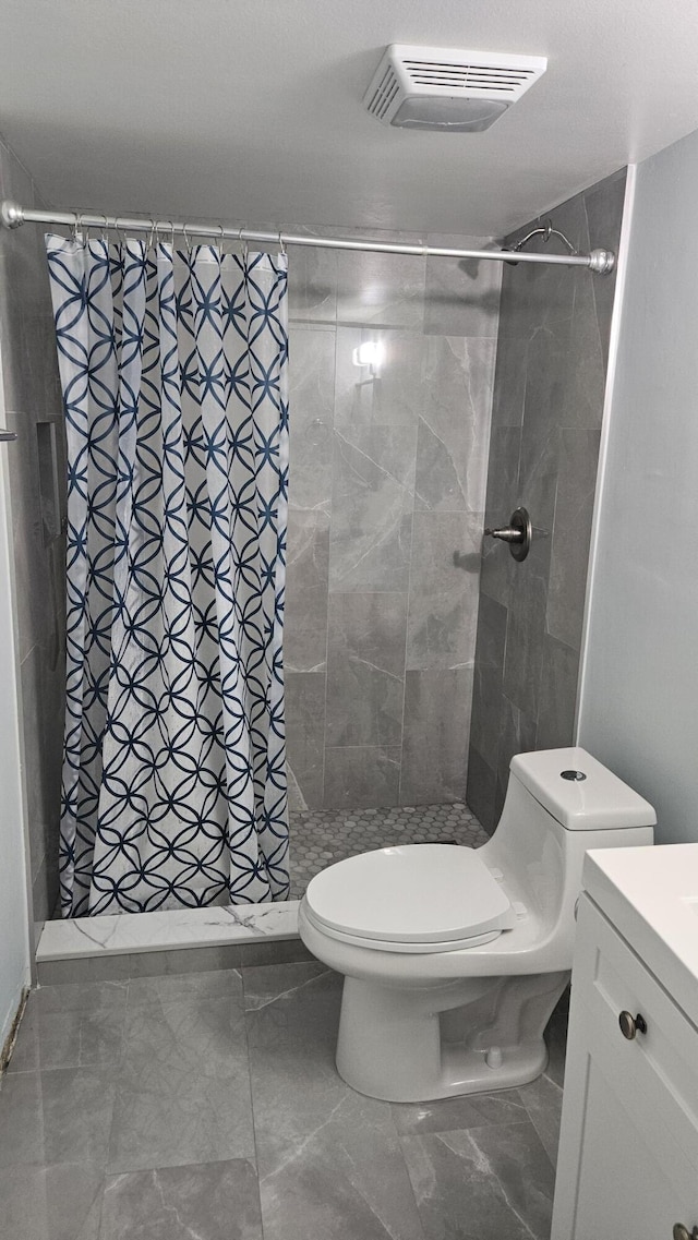full bathroom with toilet, vanity, a stall shower, and visible vents