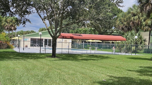 view of community featuring fence and a lawn