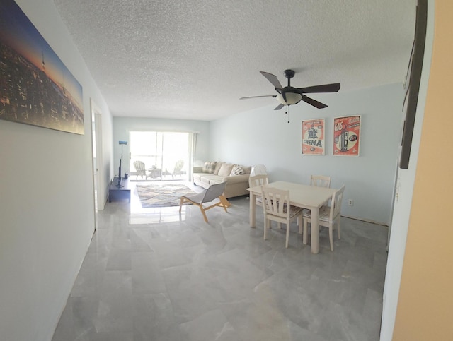 dining space with a textured ceiling and ceiling fan