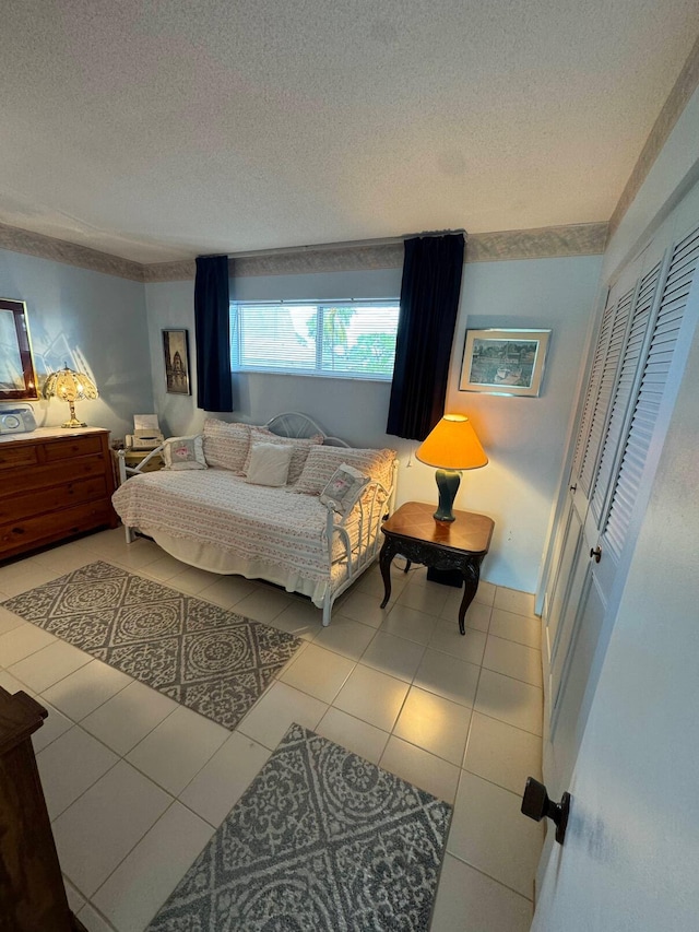 tiled bedroom featuring a closet and a textured ceiling