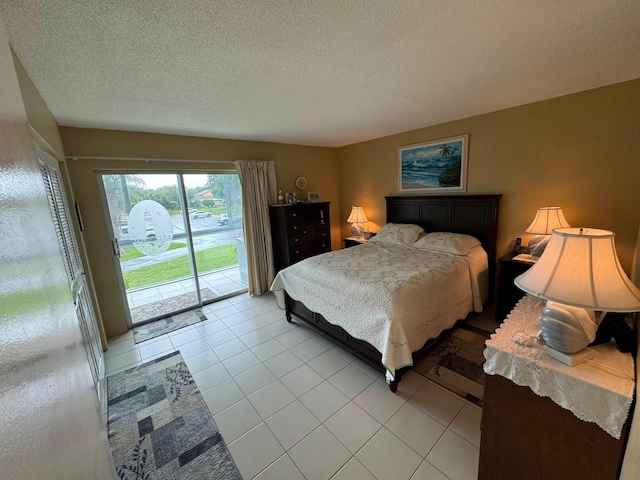 bedroom with access to exterior, light tile patterned floors, and a textured ceiling