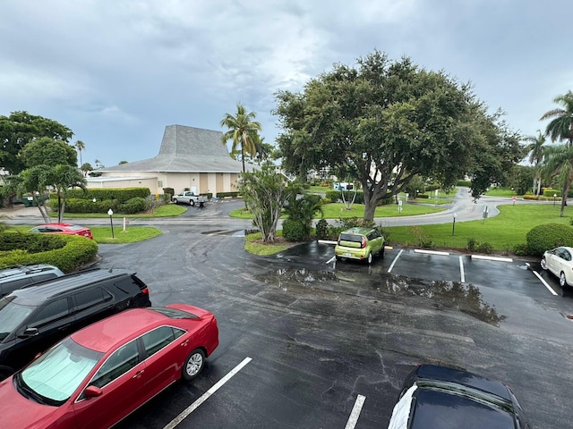 view of parking with a lawn