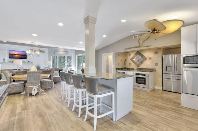 kitchen with dark stone countertops, light hardwood / wood-style floors, ceiling fan, white cabinetry, and stainless steel appliances