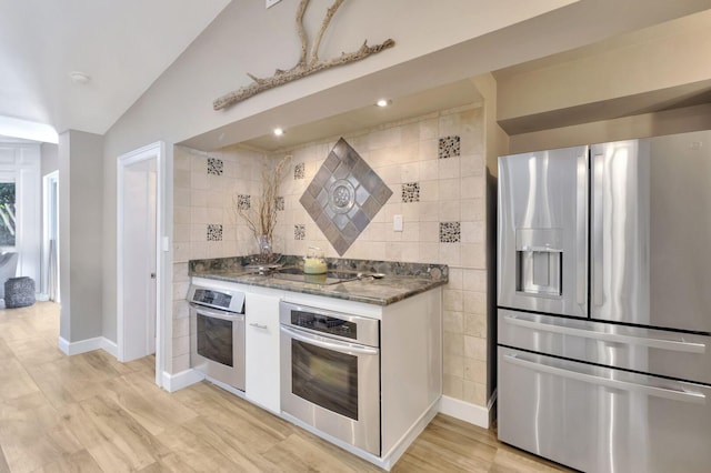 kitchen with tile walls, light wood-type flooring, backsplash, and stainless steel appliances