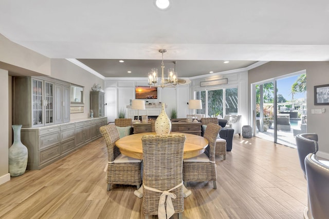 dining room with a notable chandelier, light hardwood / wood-style flooring, and ornamental molding