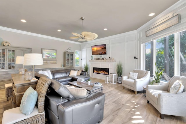 living room featuring ceiling fan, light hardwood / wood-style floors, and crown molding