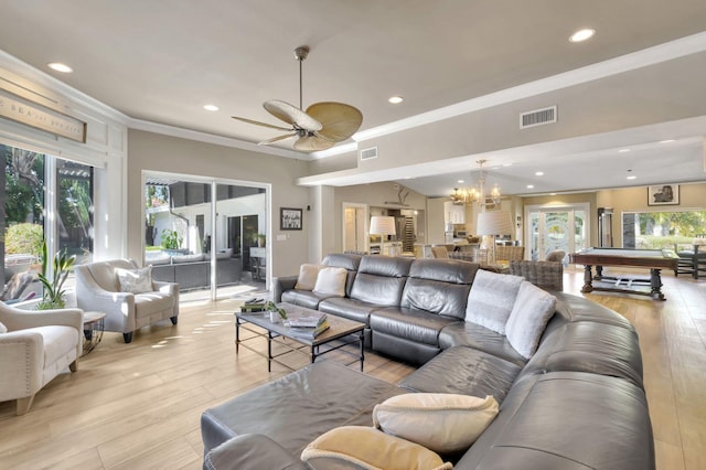 living room featuring crown molding, light hardwood / wood-style floors, and a healthy amount of sunlight