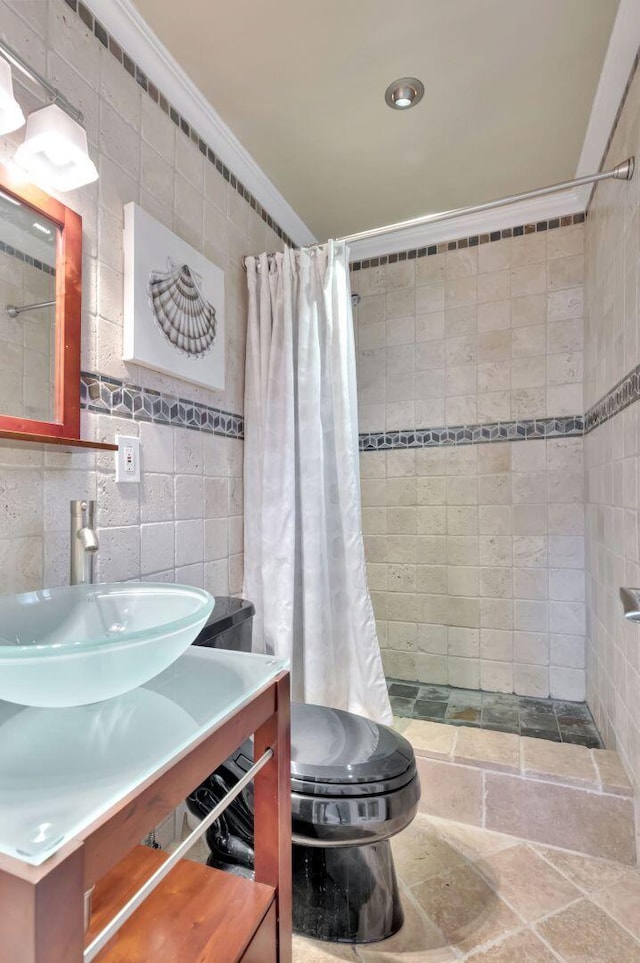 bathroom with vanity, toilet, a shower with shower curtain, and tile walls