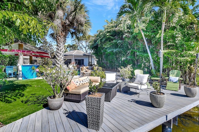 wooden terrace featuring outdoor lounge area and a lawn