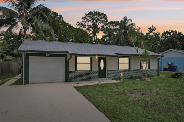 ranch-style house with a garage, a yard, and covered porch