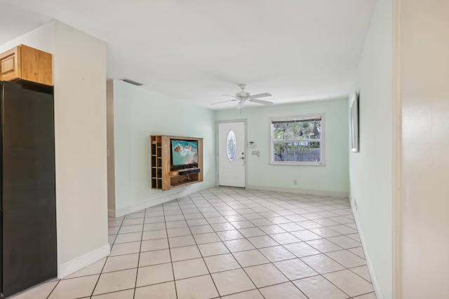 unfurnished room with light tile patterned floors and ceiling fan