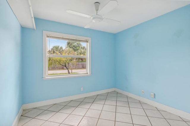 tiled spare room featuring ceiling fan