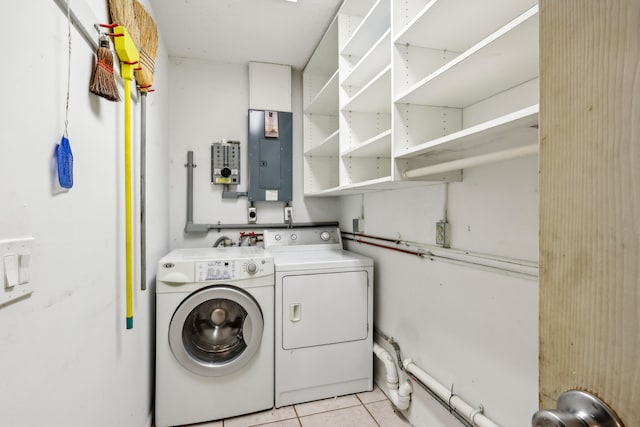 clothes washing area featuring electric panel, washer and clothes dryer, and light tile patterned floors