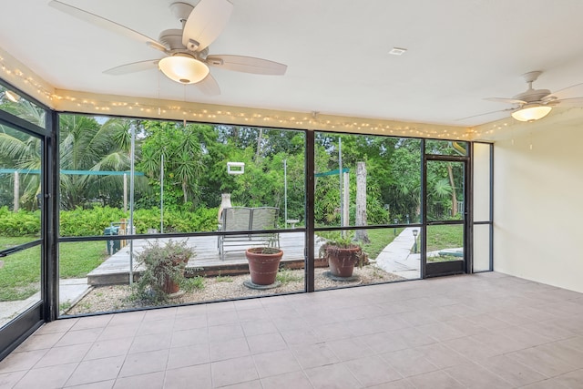 unfurnished sunroom with ceiling fan and a wealth of natural light