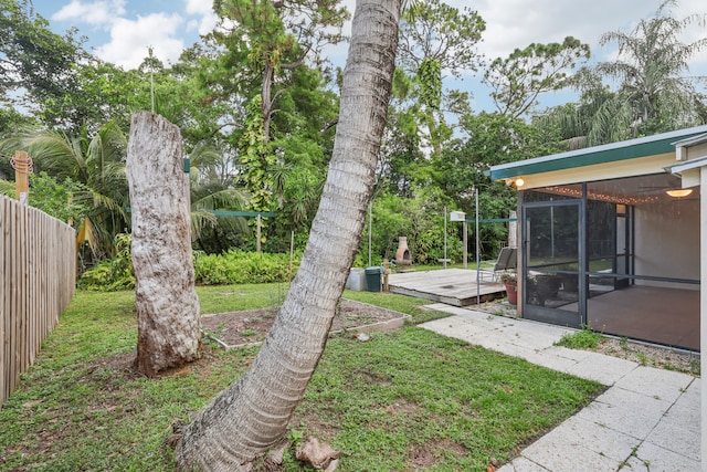 view of yard featuring a sunroom and a wooden deck