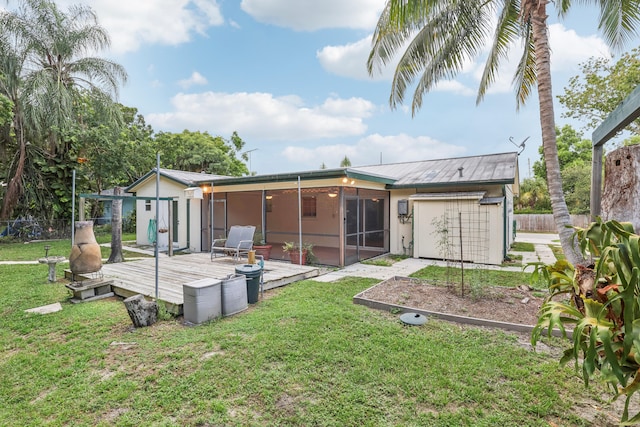 rear view of house featuring a lawn and a wooden deck