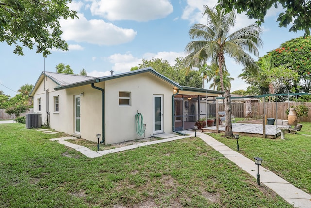 rear view of property featuring central AC, a yard, and a wooden deck