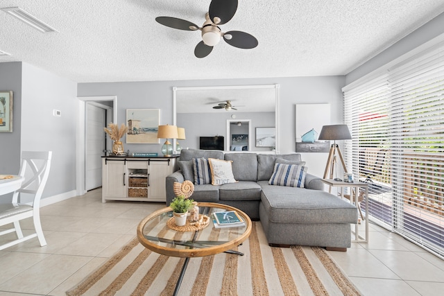 tiled living room with ceiling fan and a textured ceiling