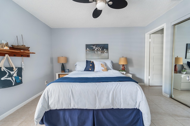 bedroom with light tile patterned flooring, a textured ceiling, a closet, and ceiling fan