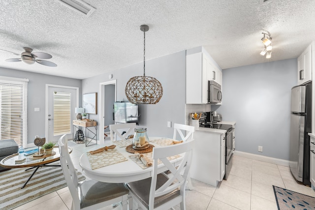 kitchen with pendant lighting, white cabinets, stainless steel appliances, and a textured ceiling