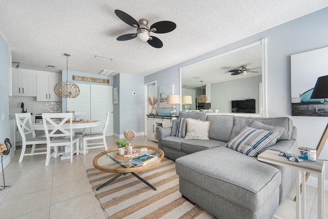 tiled living room featuring a textured ceiling and ceiling fan