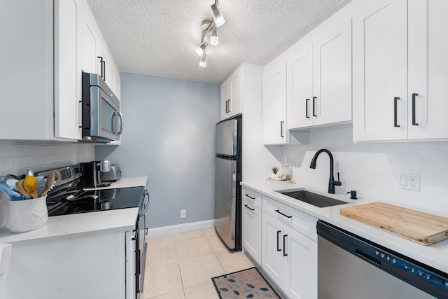 kitchen with white cabinetry, stainless steel appliances, tasteful backsplash, and sink