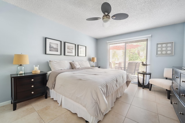 tiled bedroom with ceiling fan and a textured ceiling