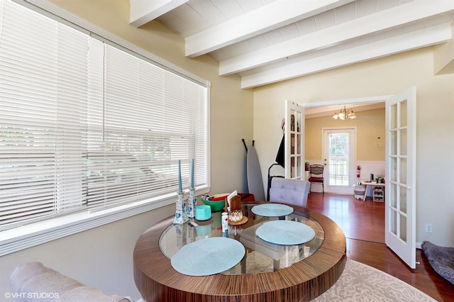 dining room with beamed ceiling, dark hardwood / wood-style floors, an inviting chandelier, and french doors