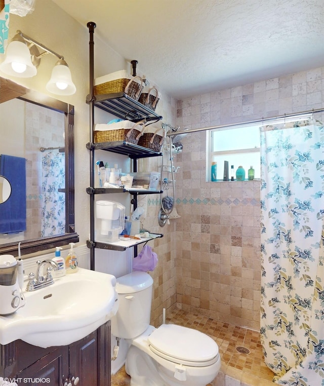 bathroom with a shower with curtain, vanity, a textured ceiling, and toilet