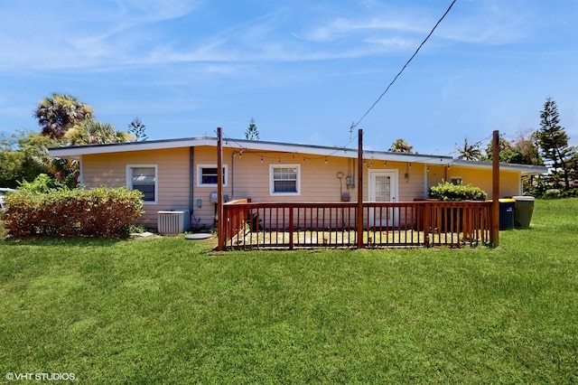 back of house with a lawn, a deck, and central air condition unit