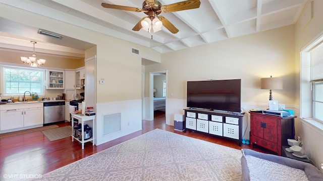 living room featuring beam ceiling, ceiling fan with notable chandelier, dark wood-type flooring, and sink